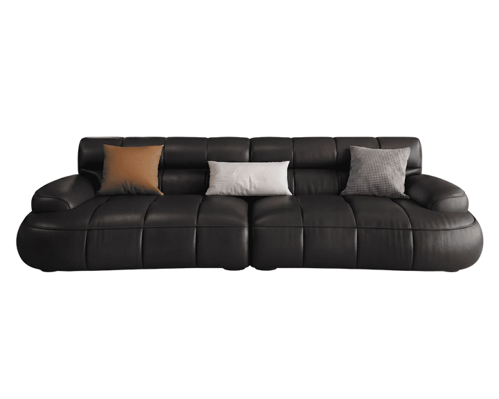 Black leather sofa with three cushions on a white background
