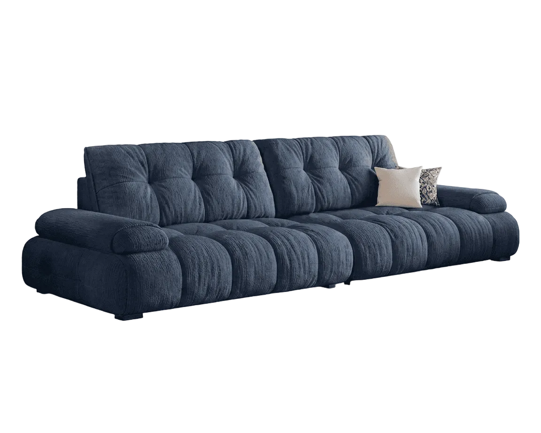 Blue tufted sofa with decorative pillows on a white background